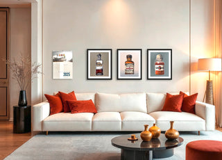 Modernes Wohnzimmer mit weißem Sofa, roten Kissen, drei gerahmten Bildern von Alkoholika Artefakt Kunstdrucken von Dominik Lommer an der Wand und Couchtisch