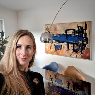 Frau steht vor dem Gemälde von Dominik Lommer im Wohnzimmer als Referenz