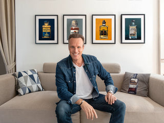 Künstler Dominik Lommer vor seinen Kunstdrucken