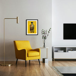 Ein Wohnzimmer mit einem gelben Stuhl, einer Lampe und einem Sideboard. An der Wand hängt ein Kunstdruck einer gelben Hennessyflasche
