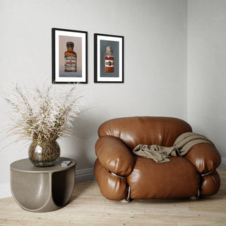 Ein Wohnzimmer mit Sessel und Beistelltisch, an der Wand hinter ihm sind zwei Kunstdrucke Alkoholika Artefakte Pernod und Martini aufgehängt. Wandbild für Wohnzimmer Poster Gescgenk für 
